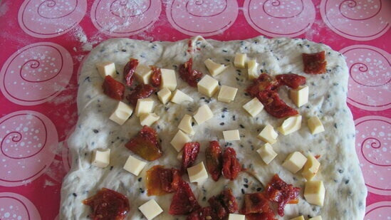 Butter bread with black sesame seeds, cheese and sun-dried tomatoes