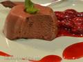Milk and chocolate dessert with cherry syrup